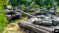 En esta imagen publicada por servicio de prensa del Ministerio ruso de Defensa el miércoles 12 de julio de 2023, tanques del grupo contratista militar ruso Wagner se ven estacionados antes de su entrega al ejército ruso en un lugar no revelado. 