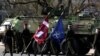 Військовослужбовці латвійської армії тримають прапори Латвії та НАТО під час святкування річниці приєднання Латвії до альянсу в Ризі, 28 березня 2024 р. REUTERS/Ints Kalnins