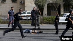 Policiers israéliens autour du corps d'un agresseur présumé palestinien à Pisgat Zeev, une colonie israélienne 12 octobre 2015. (Reuters /Ammar Awad)