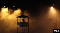 Seorang aparat keamanan terlihat berjaga-jaga di menara saat berlangsung penyemprotan anti-nyamuk di gedung yang akan dipakai untuk Pesta Plahraga Persemakmuran.