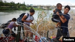Migranti iz Venecuele probijaju se kroz bodljivkavu žicu nakon što su preko reke Rio Grande ušli u Sjedinjene Države, u Igl Pasu, 26. septembra 2023.