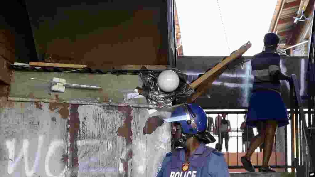 Un policier se tient devant une auberge où des manifestants anti-immigrants ont été dispersés, à Actonville, à l'est de Johannesburg, Afrique du Sud, jeudi 16 avril 2015.