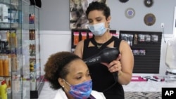 Shannon Stafford styles the hair of Ebony Housey at her salon in Savannah, Ga., April 24, 2020. 