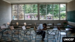 In this photo taken August 31, 2018, in Villanueva, Honduras, Darwin Martinez, 16, sits in the classroom he shared with his friend Henry, who committed suicide in September of 2016. According to a teacher, Henry and Darwin were targeted by bullies.