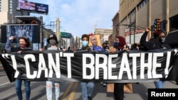 Les manifestants défilent dans le centre-ville de Minneapolis un jour avant le début de la sélection du jury pour le procès de Derek Chauvin, l'ancien policier de Minneapolis accusé d'avoir tué George Floyd, à Minneapolis, Minnesota, le 7 mars 2021.