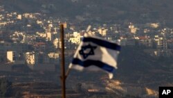 FILE - An Israeli flag flies near the Golan Heights village of Majdal Shams, Oct. 11, 2018.