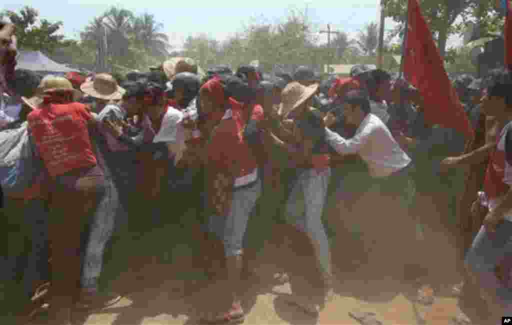 Para demonstran mahasiswa berusaha merobohkan barikade polisi dalam sebuah demonstrasi di Letpadan, Myanmar (10/3). (AP/Gemunu Amarasinghe)