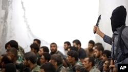 FILE - This undated file photo posted in August 2014 shows a fighter from the Islamic State. 