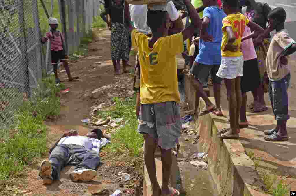 Children surround a man suspected of having contracted the Ebola virus, Monrovia, Liberia, Aug. 19, 2014. 