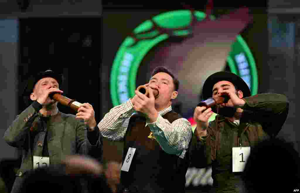Second-place Thomas Soltwedel, left, winner Fabian Menzel and third-place Jerome Boehm, right, perform after the German Deer Calling Championship on the sidelines of the Jagd & Hund (Hunting and Dog) trade fair in Dortmund, Germany.