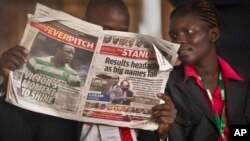 Un homme et une femme lisent le journal The Standard avec sur la manchette un titre consacré aux résultats de la présidentielle à Nairobi, Kenya, 7 mars 2013.