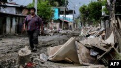 Un hombre camina por una calle dañada tras el paso del huracán Eta en La Lima, Cortes, Honduras, el 16 de noviembre de 2020.