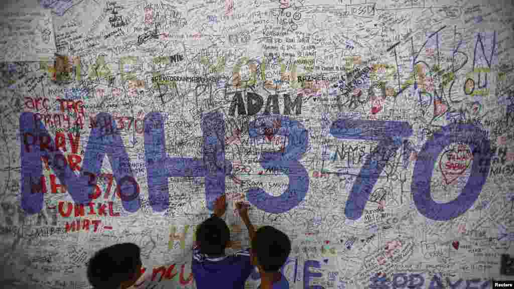 Des enfants écrivent des messages d'espoir pour les passagers du Vol MH370, le 14 juin 2014.