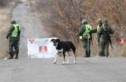 FILE - Servicemen of the separatist Donetsk People's Republic stand guard at a checkpoint in the settlement of Petrovskoye (Petrivske), near the contact line with the Ukrainian armed forces in Donetsk region, Ukraine, Nov. 4, 2019.