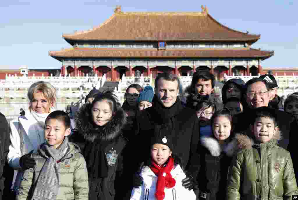 2018年1月9日,法国总统马克龙和夫人布丽吉特·马克龙(Brigitte Macron)参观北京故宫,在紫禁城里和中法两国学生合影。。