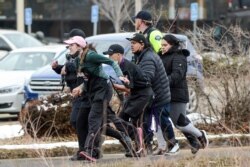 King Soopers employees are led away from an active shooter at the King Soopers grocery store in Boulder, Colorado, March 22, 2021. Police say 10 people were killed in the shooting, including a police officer.