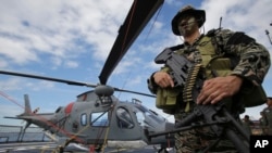 菲律賓海軍特種部隊隊員12月17日在艦載直升機旁留影 