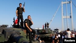 Les policiers sont montés sur des véhicules blindés de l'armée après que les troupes impliquées dans le coup d'Etat se sont rendus, sur le pont du Bosphore à Istanbul, Turquie, 16 juillet 2016. REUTERS / Murad Sezer 