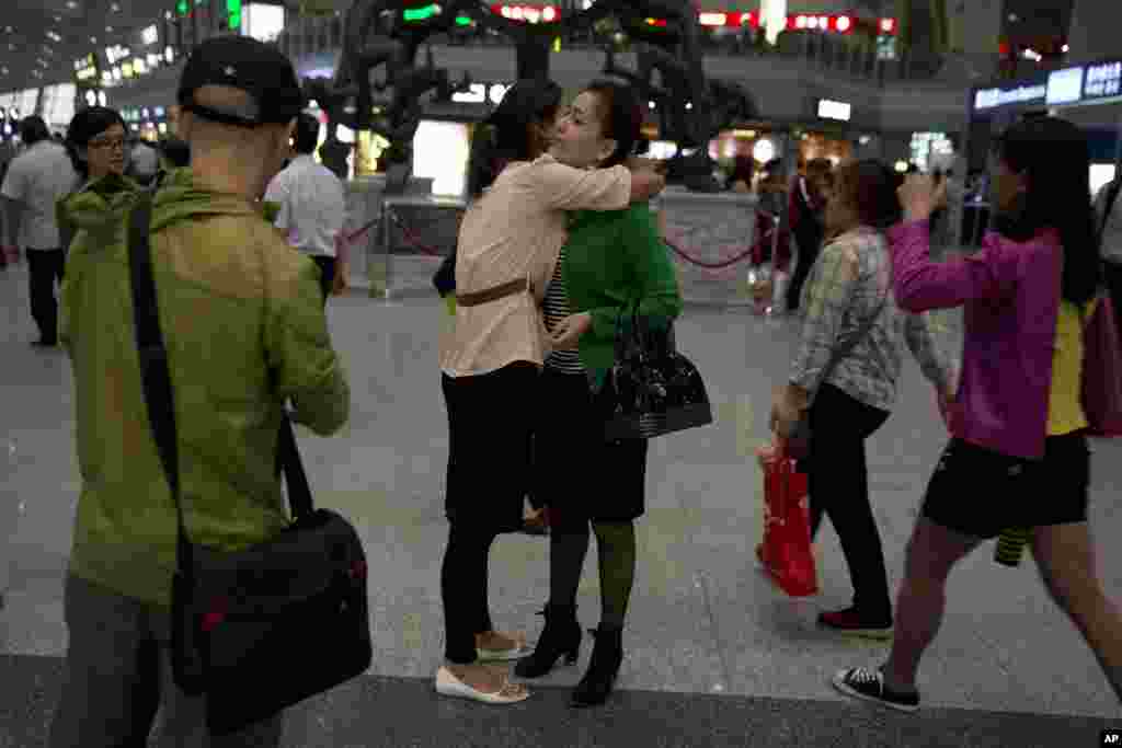 Guzulnur, wife of detained Uighur scholar, Ilham Tohti, bids farewell to friends before leaving on a flight for Urumqi, at the Capital Airport in Beijing, China, Sept. 15, 2014.