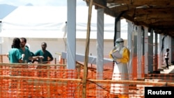 FILE - A health worker dressed in a protective suit talks to medical staff at the newly constructed MSF (Doctors Without Borders) Ebola treatment center in Goma, Democratic Republic of Congo, Aug. 4, 2019.