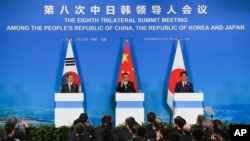 PM China Li Keqiang (tengah), Presiden Korea Selatan Moon Jae-in (kiri) dan PM Jepang Shinzo Abe (kanna) dalam konferensi pers di Chengdu, China (24/12).