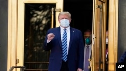 特朗普總統接受新冠病毒治療後走出沃爾特·里德國家軍事醫療中心，準備乘“海軍陸戰隊一號”專用直升機返回白宮。 (2020年10月5日)