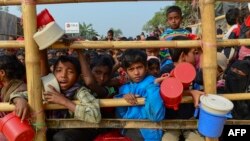 Rohingya refugees wait for food aid at Thankhali refugee camp in Bangladesh's Ukhia district on January 12, 2018.