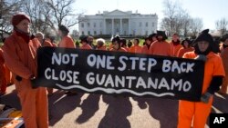 Les manifestants qui dépeignent les prisonniers de Guantanamo tiennent des pancartes demandant la fermeture du centre de détention de Guantanamo Bay à Cuba, lors d'un rassemblement à la Maison Blanche à Washington, le 11 janvier 2016.