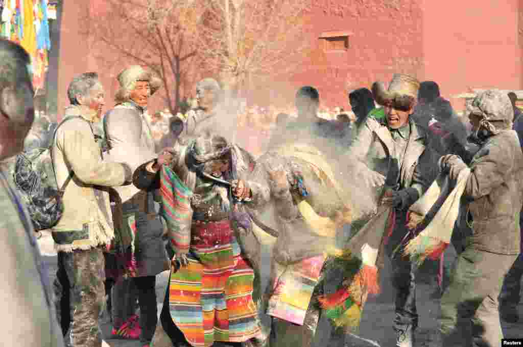 Tibetans throw "zanba," traditional roasted flour, at each other during a zanba fight event to pray for a good harvest in Shigatse, Tibet Autonomous Region, China, Feb. 22, 2016.