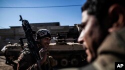 An Iraqi soldier carries a machine gun while heading to the front line in Mosul, Iraq, Dec. 6, 2016. IS commanders have “been adapting all along,” changing tactics to keep Iraqi forces off-balance as the latter push further into Mosul, a U.S. official said.