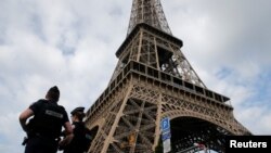 FILE - French police patrol near the Eiffel tower as part of security measures in Paris, France, July 13, 2017.