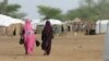 Des femmes maliennes marchent dans le camp de réfugiés de Goudebou au Burkina Faso, 26 juillet 2013. PHOTO AFP / AHMED OUOBA / PHOTO AFP / AHMED OUOBA