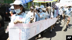 In this photo taken on Friday, May 4, 2012, Cambodian protesters from Boueng Kak lake march with a banner displaying the thumb prints of fellow land owners who have been evicted from their homes, as they demand compensation, in Phnom Penh, file photo.