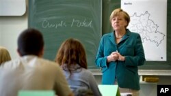 Nakon što je napisala svoje ime na tabli, nemačka kancelarka započela je čas posvećen Berlinskom zidu. 