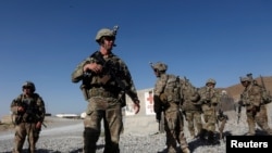 FILE - U.S. troops wait for their helicopter flight at an Afghan National Army (ANA) base in Logar province, Afghanistan, Aug. 7, 2018. 
