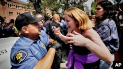 Una manifestante de la Universidad del Sur de California se enfrenta a un oficial de Seguridad Pública de la Universidad en el Alumni Park del campus durante una ocupación pro-palestina el miércoles 24 de abril de 2024 en Los Ángeles. (Foto AP/Richard Vogel)