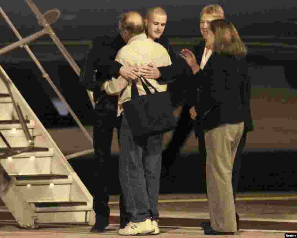 Matthew Todd Miller, center, facing camera, reunites with his family members after landing at McChord Field at Joint Base Lewis-McChord, Washington, Nov. 8, 2014.