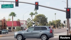 FILE -A self-driving Volvo vehicle, purchased by Uber, moves through an intersection in Scottsdale, Arizona, Dec. 1, 2017. 