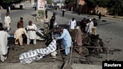 Polisi dan petugas penyelamat menutupi jenazah korban tewas akibat ledakan di Quetta, Pakistan, Jumat (23/6). 