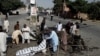 Police and rescue officials cover a body after a blast in Quetta, Pakistan, June 23, 2017. 
