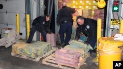 Esta fotografía del 28 de febrero de 2019, proporcionada por la Oficina de Aduanas y Protección Fronteriza, muestra a agentes aduanales que descargan un camión que contiene 1.451 kilos (3.200 libras) de cocaína en 60 paquetes, en el puerto de Nueva York/Newark.