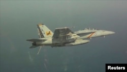 Pesawat tempur Amerika F/A-18F Super Hornet tampak di langit Teluk Arab. Gempuran pesawat tempur AS berhasil memperlambat operasi kelompok ISIS namun tidak tuntas melemahkan ISIS, demikian dikatakan Pentagon (10/8/2014).