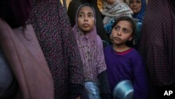 Timoun Palestinyen fe lake nan yon sant distribisyon manje nan Deir-al-Balah, Gaza, 22 Nov. 2024.