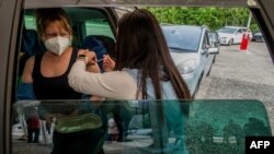 Žena dobija Fajzerovu vakcinu protiv Kovida-19 u svom automobilu u Pilsenu u Češkoj Republici, 21. maja 2021. 