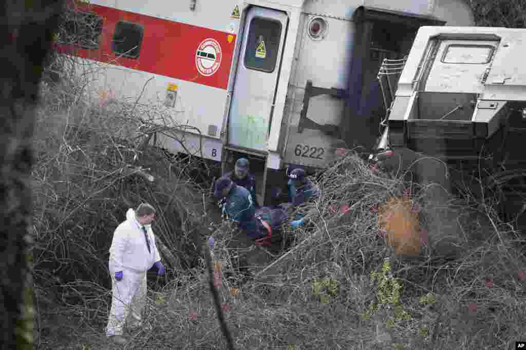 Tim SAR memindahkan mayat dari tempat tergulingnya kereta penumpang Metro-North di Bronx, New York, 1 Des., 2013.
