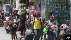 Residentes abandonan sus hogares en su huida de los enfrentamientos entre pandillas armadas en el distrito Carrefour-Feuilles de Puerto Príncipe, el 15 de agosto de 2023