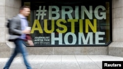 FILE - A banner for journalist Austin Tice, who disappeared while reporting in Syria in 2012, hangs outside the National Press Club building in Washington, May 2, 2023. 