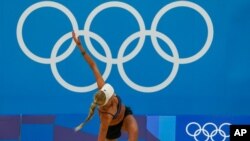 La alemana Margareta Kozuch se estira durante una sesión de entrenamiento de voleibol de playa, el 20 de julio de 2021, en Tokio.