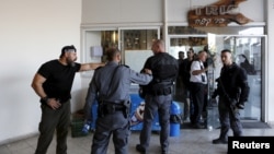 Israeli policemen stand at the scene of a Palestinian stabbing attack in Tel Aviv, Israel, Nov. 19, 2015.