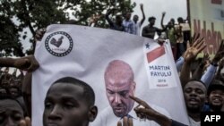 La police se tient devant les partisans du leader de l'opposition en République démocratique du Congo et candidat à la présidence, Martin Fayulu, alors qu'ils participent à une manifestation pour contester les résultats de l'élection présidentielle du 11 